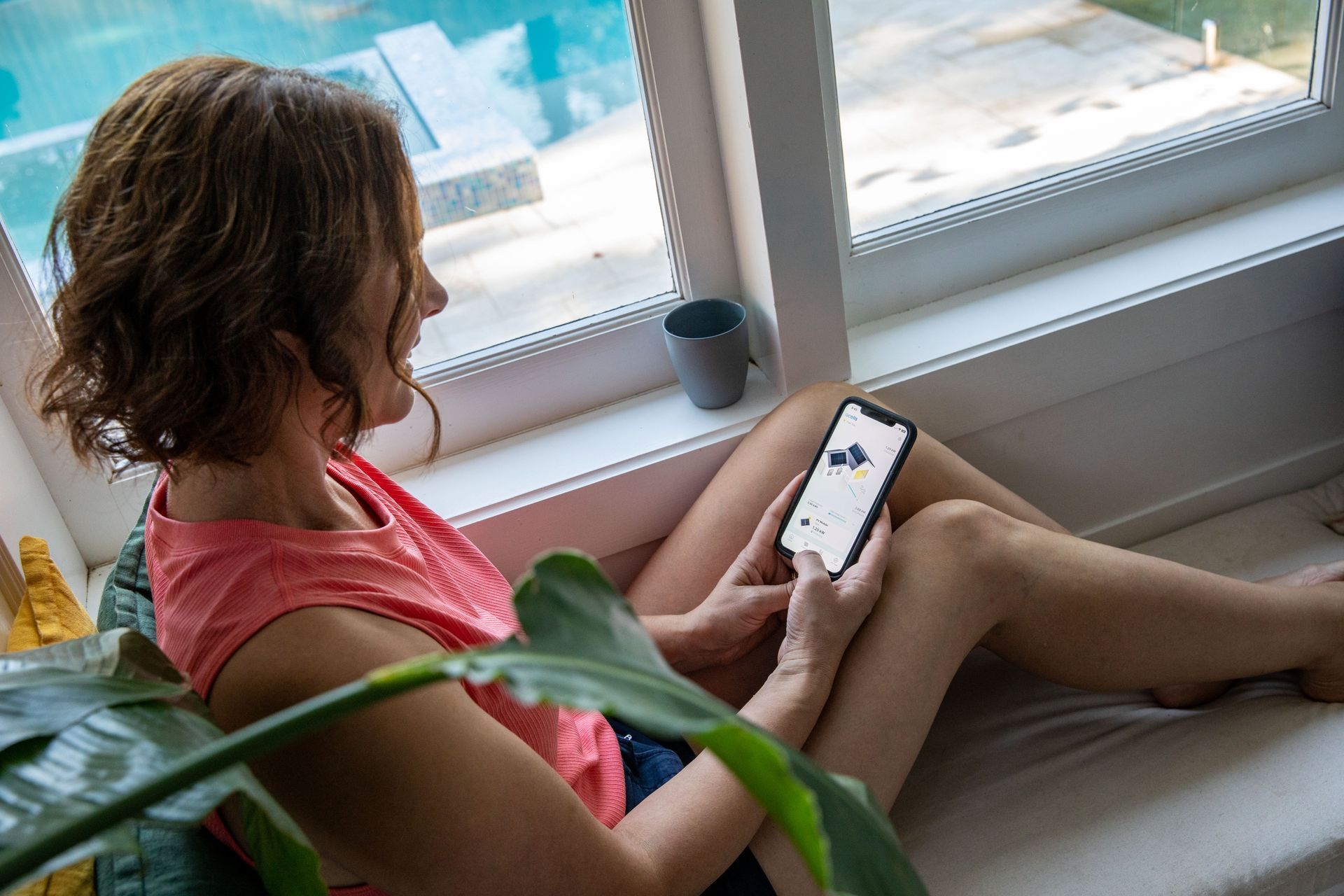 A woman using a phone to monitor her solar system