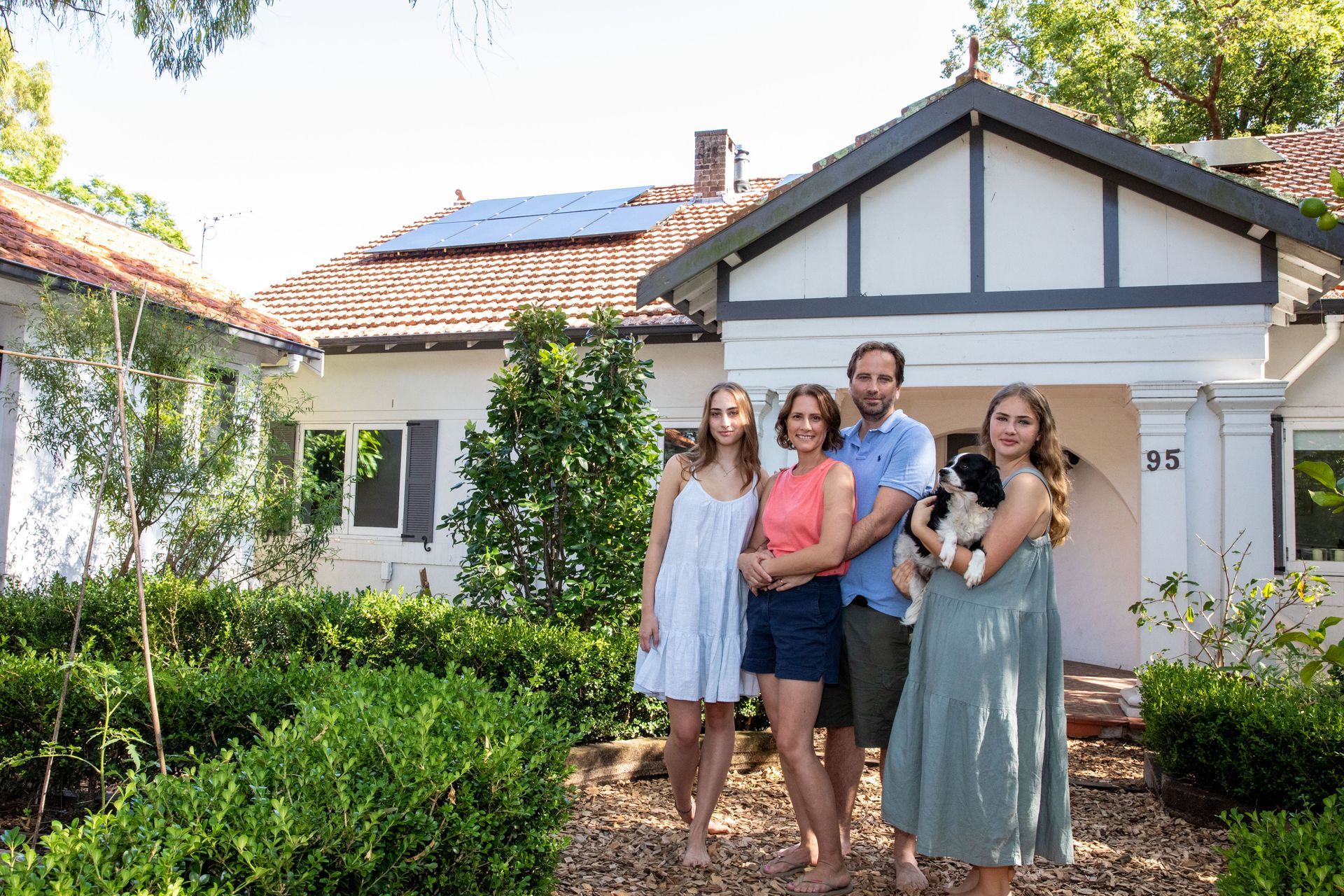 A family standing in front of their solar-powered home